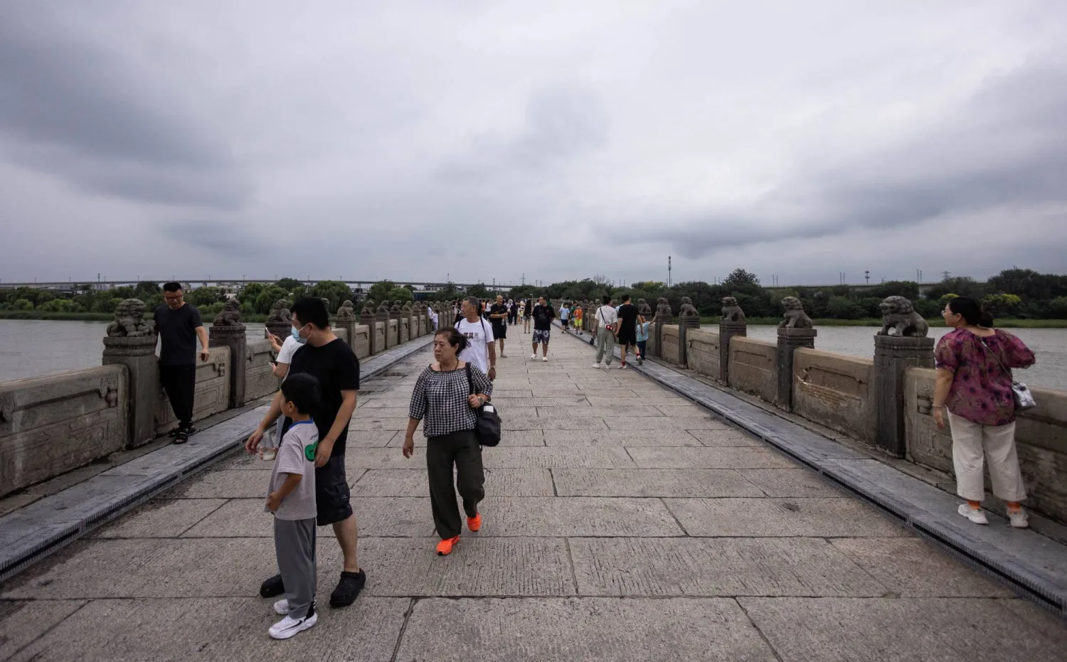 مشاة على «جسر ماركو بولو» الأيقوني في العاصمة الصينية بكين (رويترز)