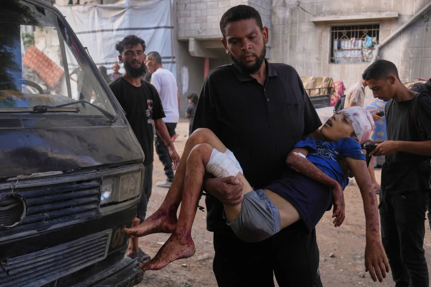 رجل يحمل جثة عبد الرحمن (12 عاماً) وهو طفل فلسطيني قُتل في غارة عسكرية إسرائيلية على قطاع غزة خلال وصولهما إلى مستشفى «الشفاء» بمدينة غزة اليوم (أ.ب)