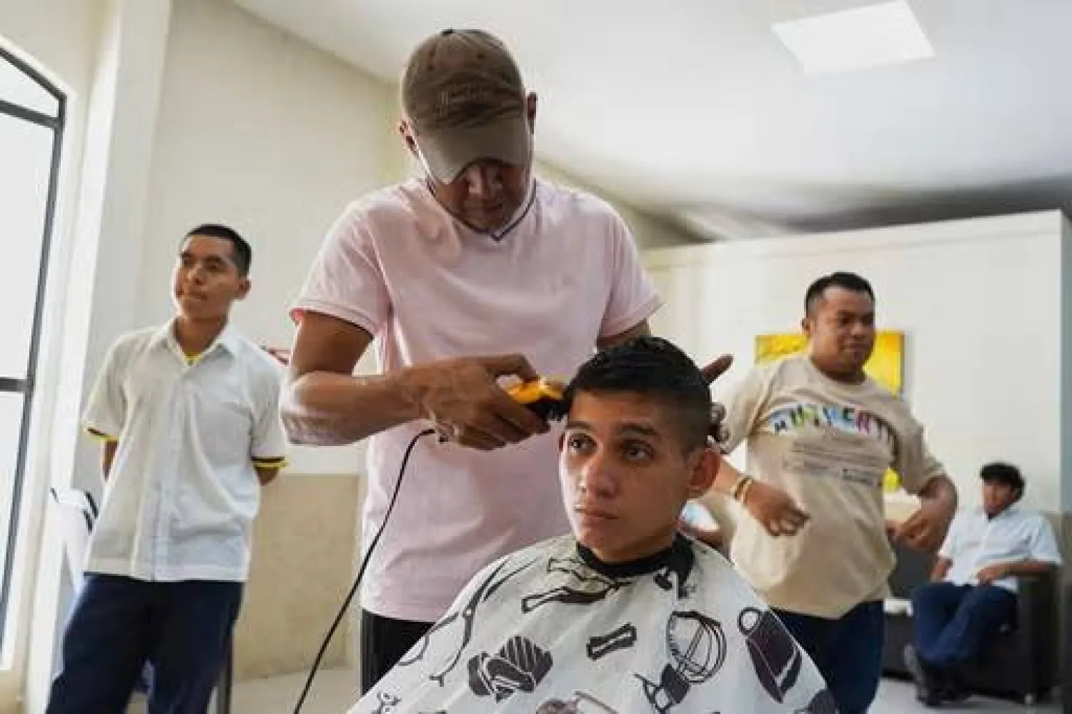 A youth gets his hair cut at a barbershop to adhere to public school rules for hair in San Salvador, El Salvador, Friday, Aug. 22, 2025. (AP Photo/Salvador Melendez)
