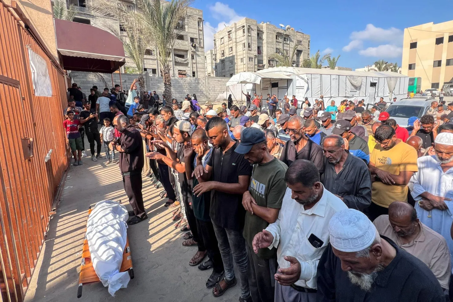 فلسطينيون خلال تشييع قتيل سقط بالقصف الإسرائيلي على خان يونس في غزة (رويترز)