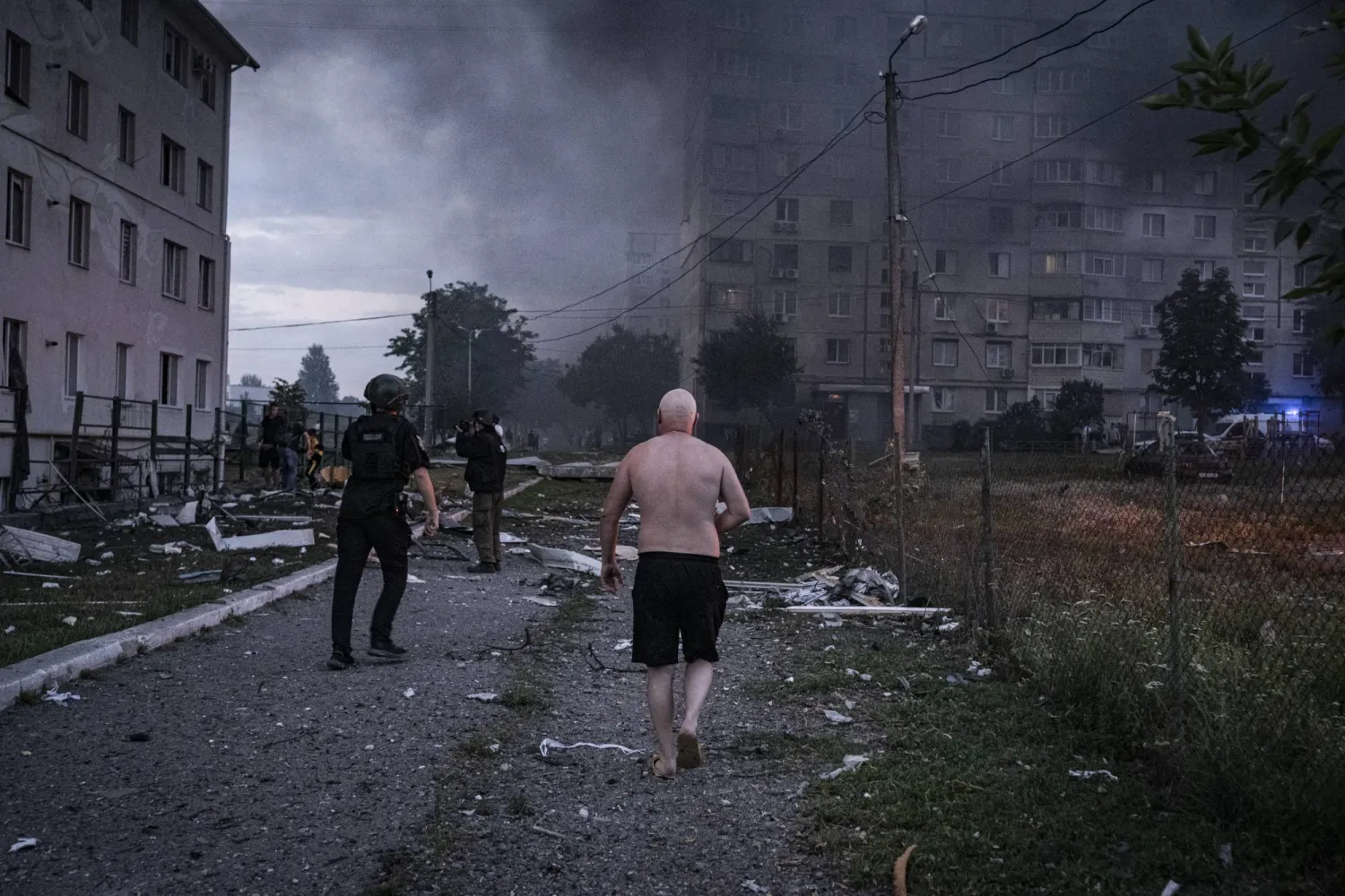 رجال إنقاذ أوكرانيون يعملون في موقع غارة بطائرة مسيرة على منطقة سكنية في خاركيف (د.ب.أ)