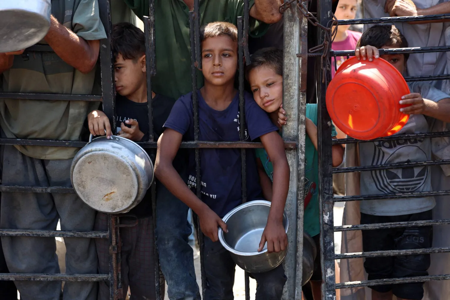 فلسطينيون يحملون أواني طعام فارغة في مدينة غزة (أ.ف.ب)