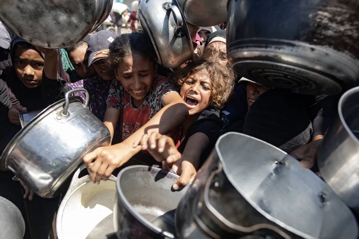 Palestinians queue to receive a meal from a kitchen that provides free food for displaced people in Khan Younis, southern Gaza Strip, on 23 August, 2025. (EPA)