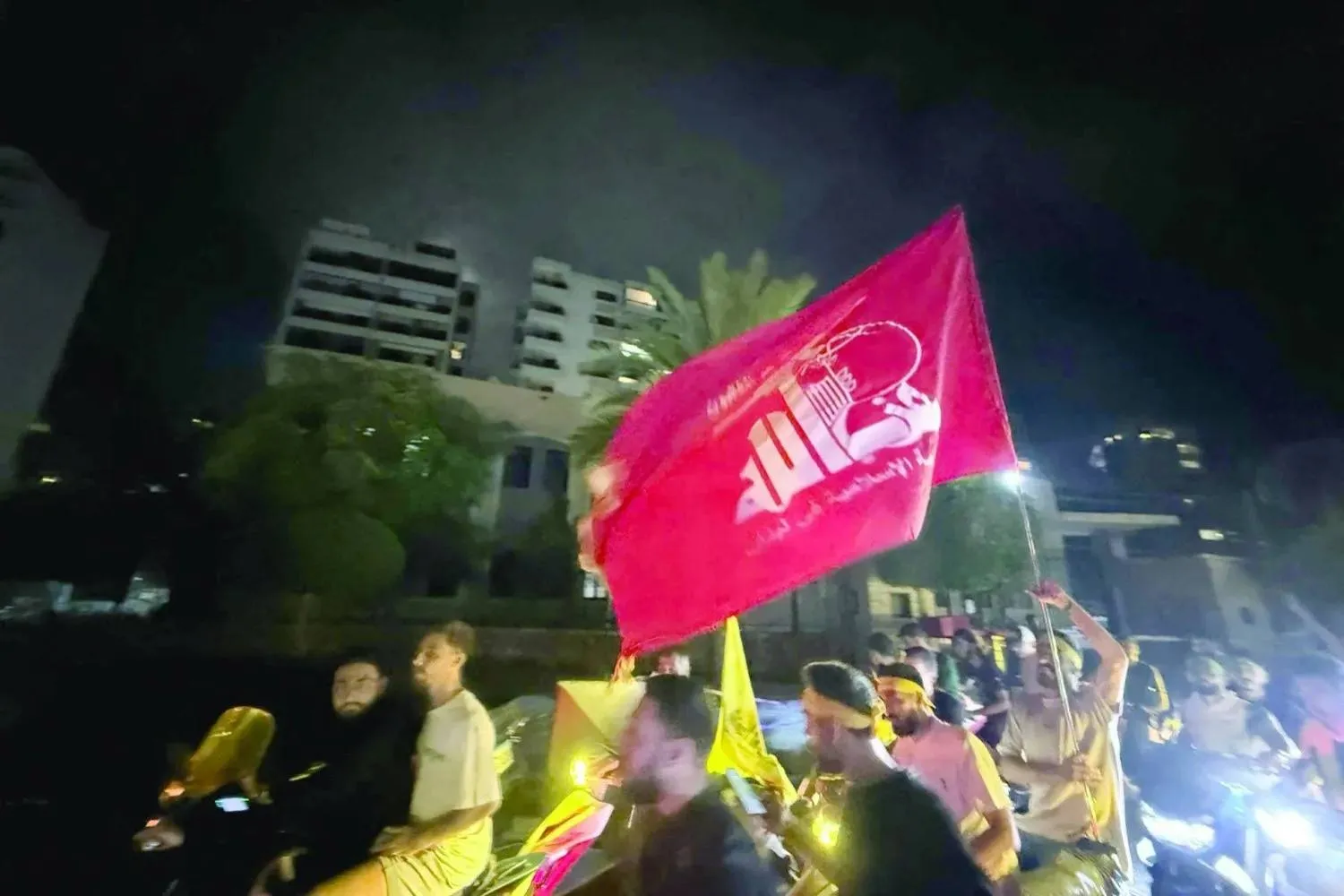 Supporters of Lebanon's Hezbollah lift flags as they rally in cars and motorbikes to protest the government's endorsement of a plan to disarm it, in Beirut’s southern suburb on August 7, 2025. (Photo by Ibrahim AMRO / AFP)