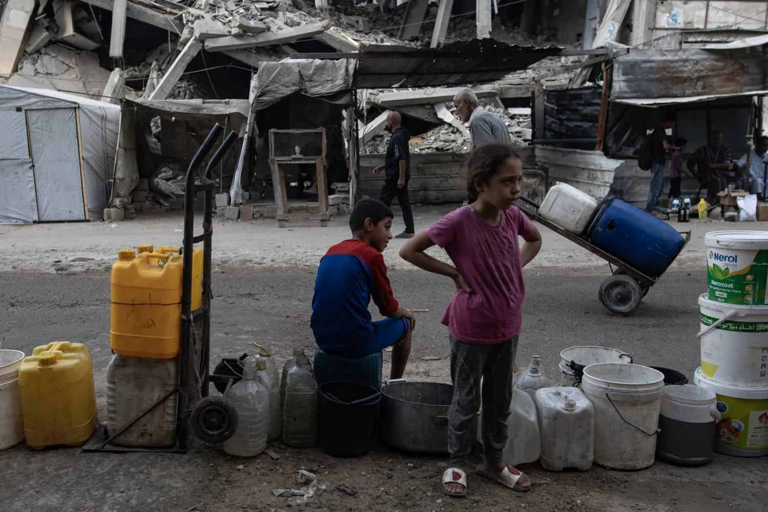 Displaced Palestinians wait to fill containers with drinking water amid the destruction in the Khan Younis camp, southern Gaza Strip, 24 August 2025. EPA/HAITHAM IMAD