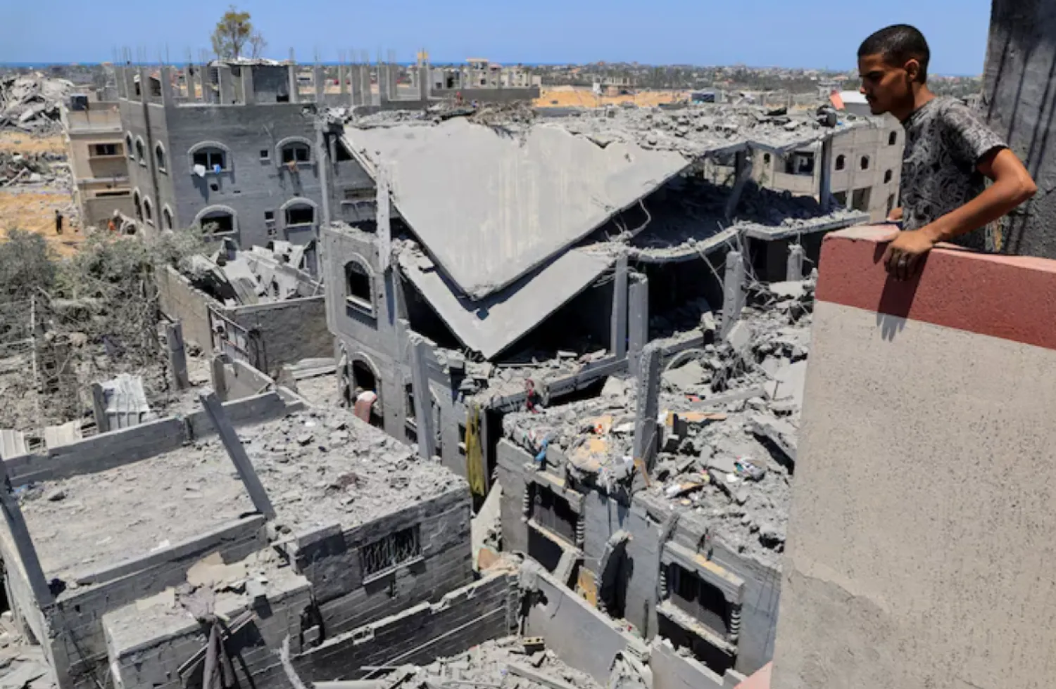 A Palestinian inspects the damage on houses destroyed during an Israeli military operation, in Deir al-Balah, central Gaza Strip, July 23, 2025. REUTERS/Hatem Khaled/File Photo