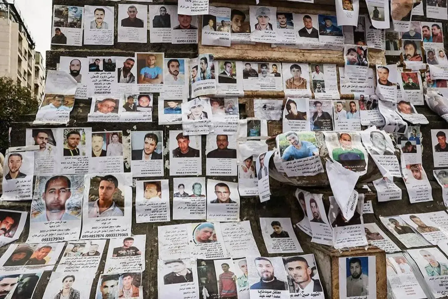 Şam'ın merkezindeki Merce Meydanı'nda sergilenen Sednaya Hapishanesi’nde tutulurken kaybolduğu düşünülen kişilerin fotoğrafları (Arşiv- Reuters)