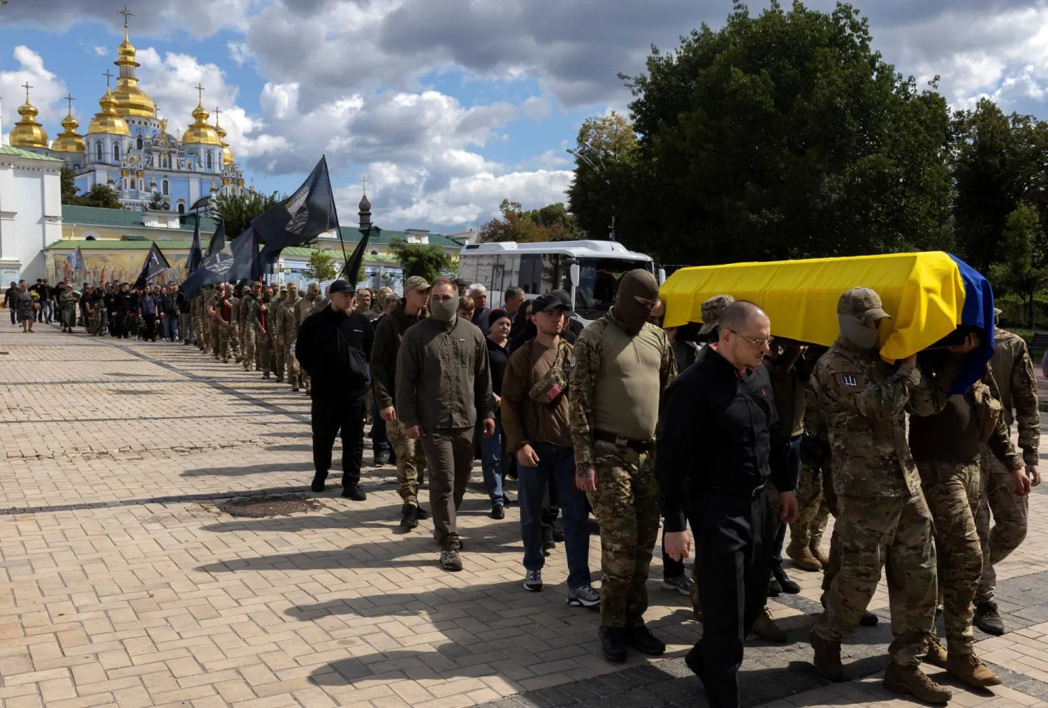  جنود أوكرانيون يحملون نعش رفيق لهم خارج دير القديس ميخائيل في كييف الاثنين وسط الهجوم الروسي على بلادهم (رويترز)