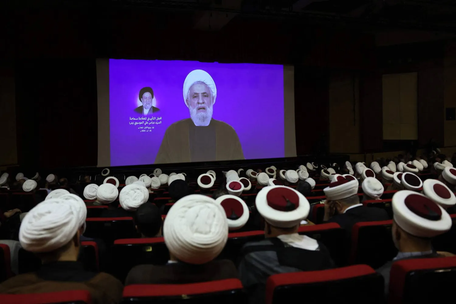 أمين عام «حزب الله» نعيم قاسم متحدثاً عبر الشاشة في حفل تأبين أمين عام الحزب السابق عباس الموسوي (أ.ف.ب)