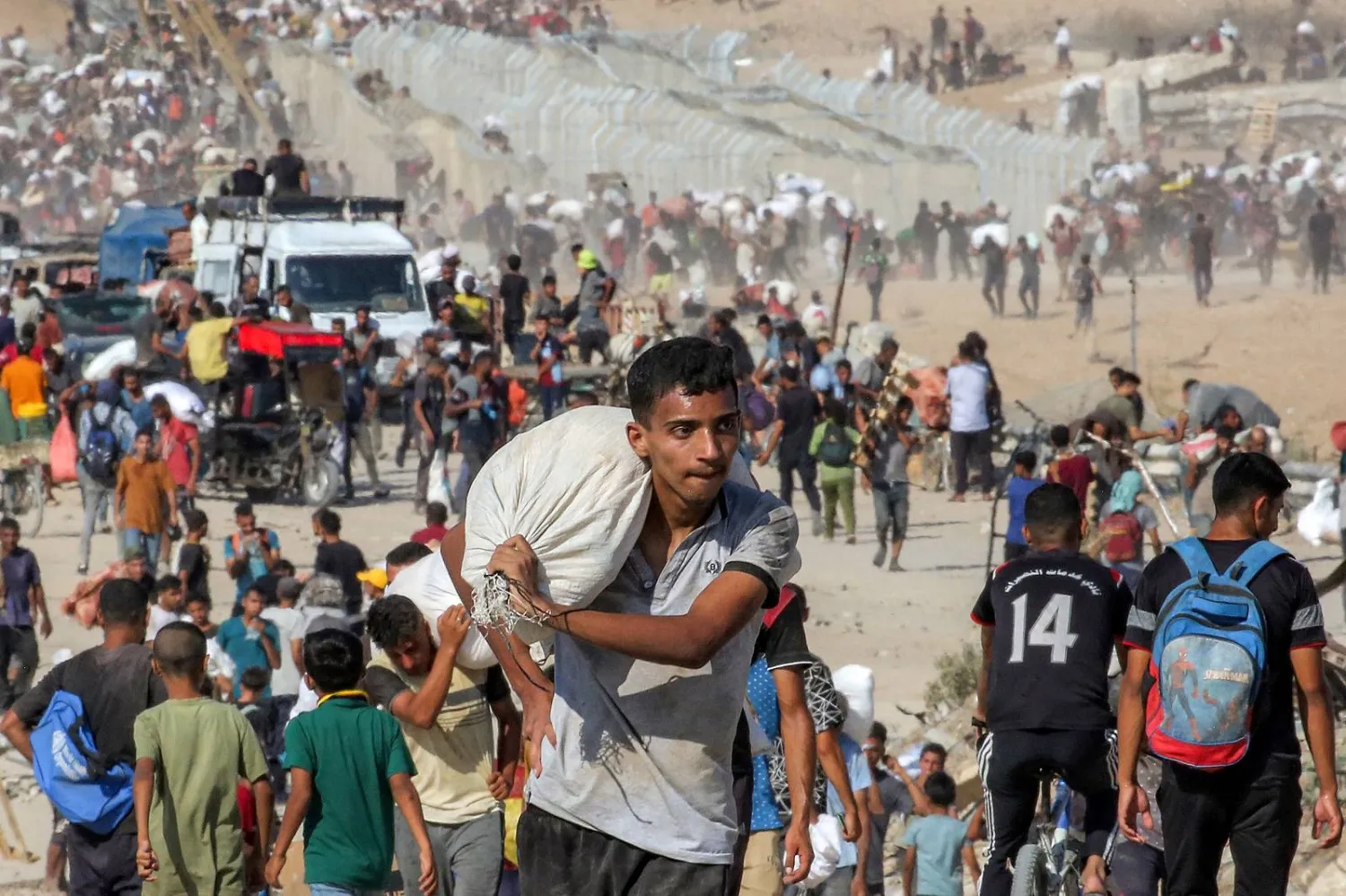 فلسطيني يحمل كيساً من المساعدات وسط قطاع غزة (أ.ف.ب)