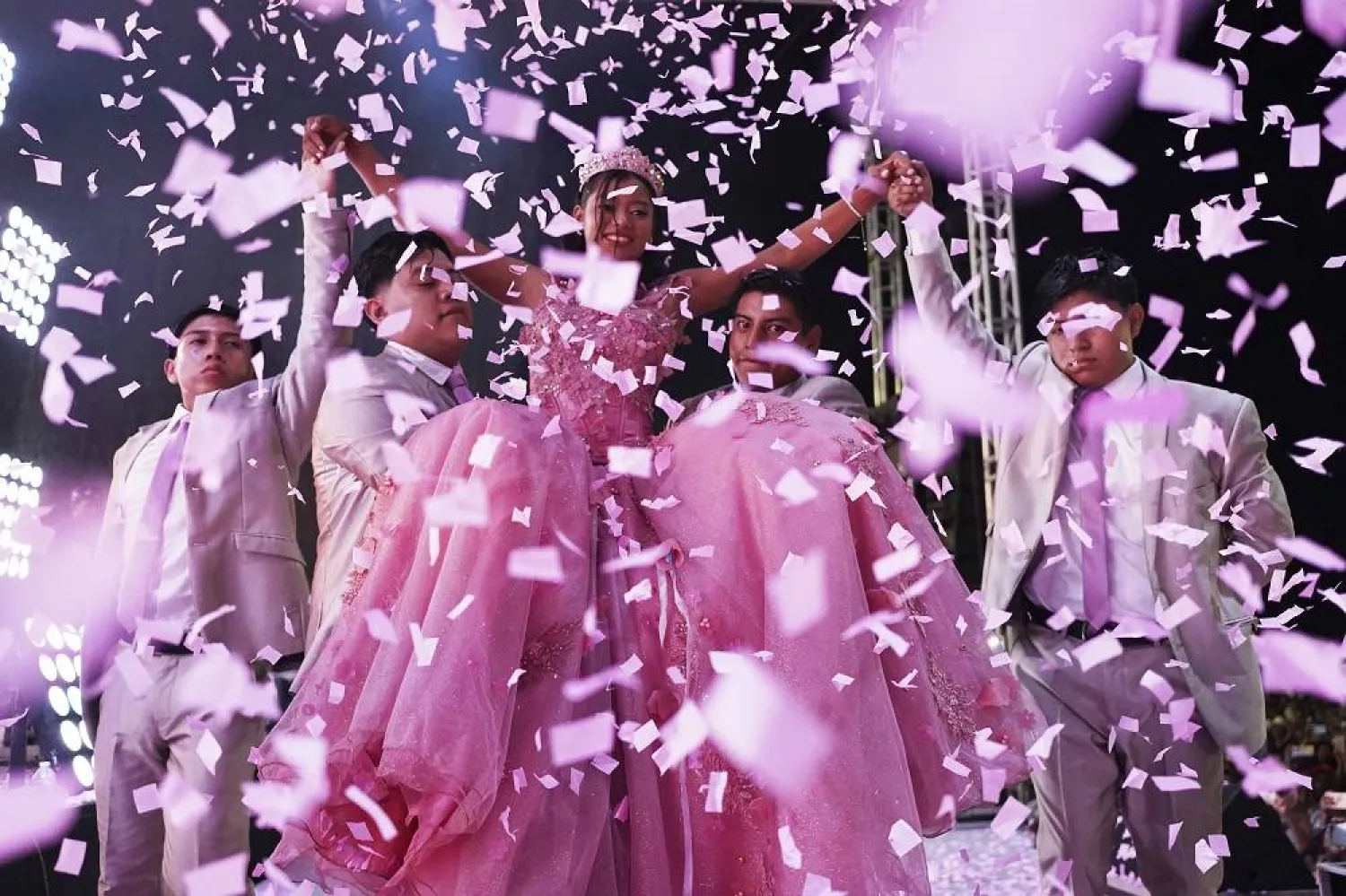 Confetti falls over Isela Anahí Santiago Morales during her 15th birthday party at a stadium in Axtla de Terrazas, Mexico, Saturday, Aug. 23, 2025, organized by the community after her father's social media appeal drew support following her first sparsely attended celebration. (AP Photo/Mauricio Palos)