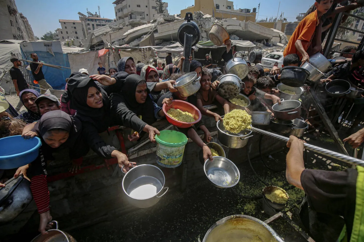 24 August 2025, Palestinian Territories, Gaza: Palestinians wait to receive food from a charity kitchen, amid the on going famine. Photo: Omar Ashtawy/APA Images via ZUMA Press Wire/dpa
