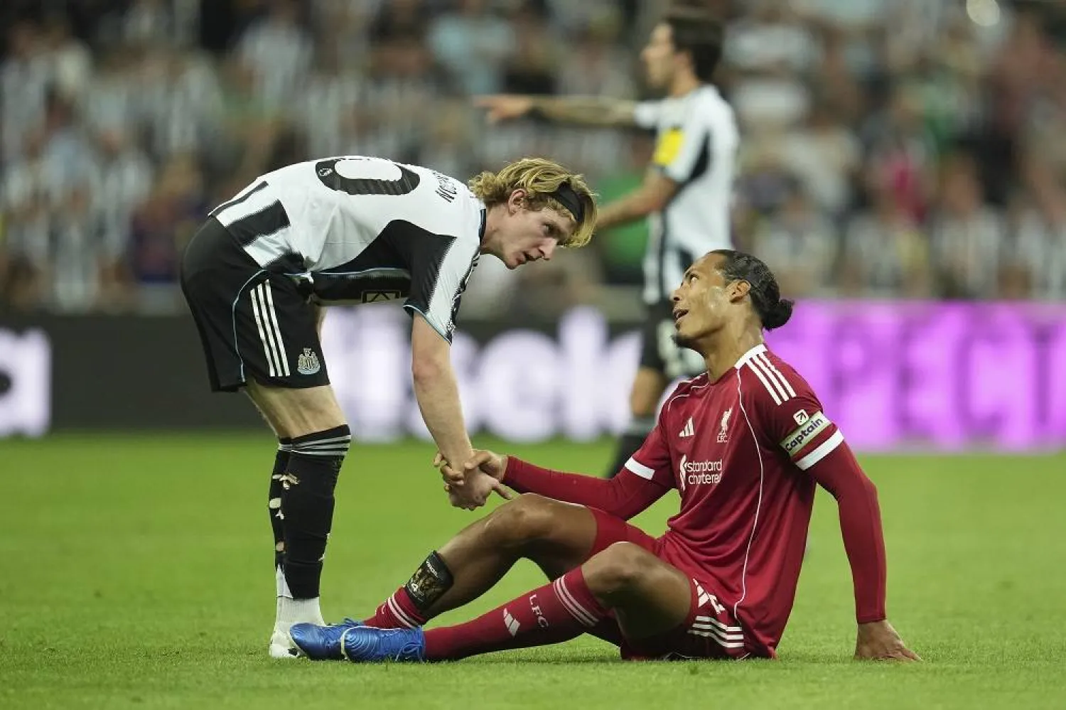 Newcastle's Anthony Gordon checks on Liverpool's Virgil van Dijk during the Premier League soccer match between Newcastle and Liverpool in Newcastle, England, Monday, Aug. 25, 2025. (AP)