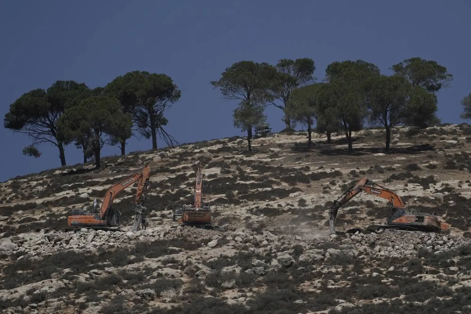 Israeli bulldozers work on a hill following an Israeli military raid in the West Bank village of Al-Mughayyir, Sunday, Aug. 24, 2025. (AP)
