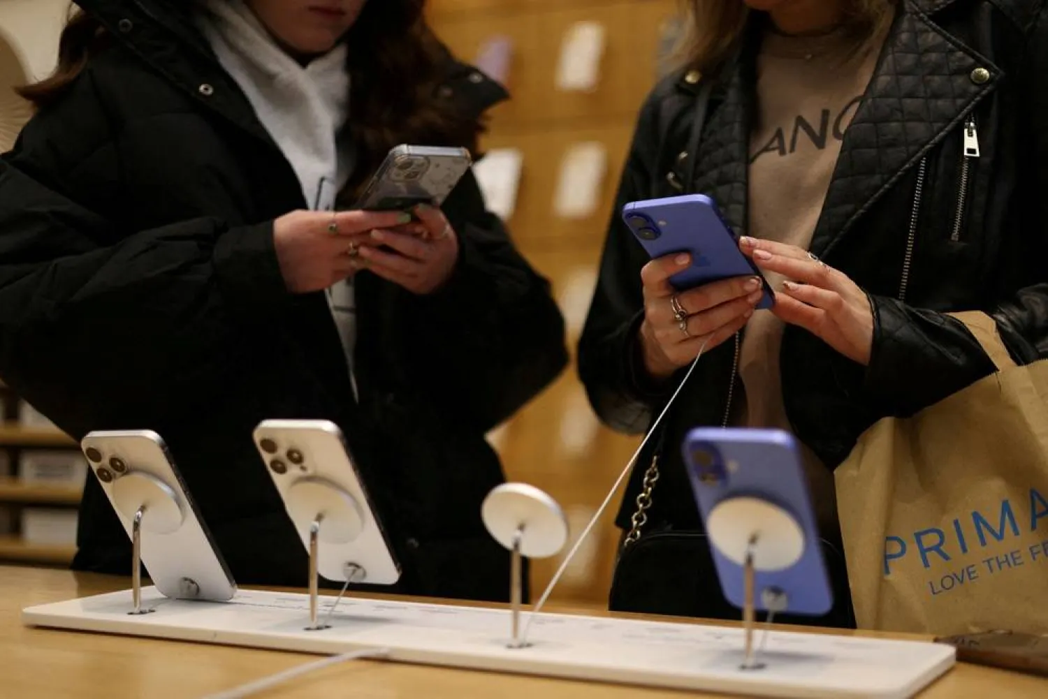 People use Apple iPhone smartphones at a store in London, Britain, October 6, 2024. (Reuters) 