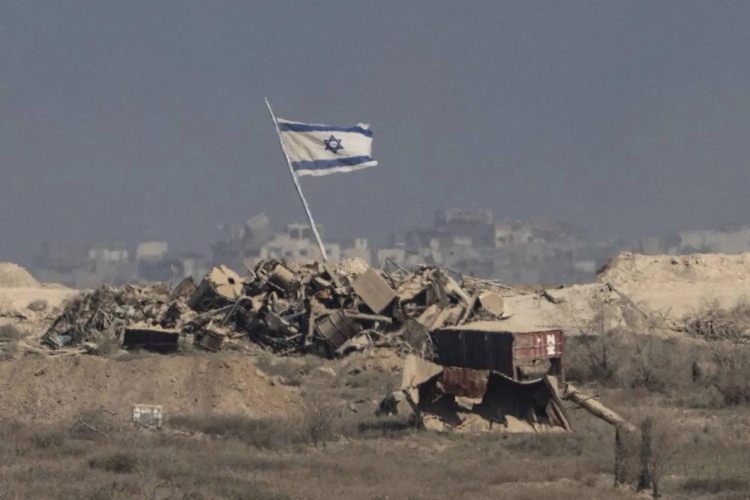  An Israeli flag waves over debris in an area of the Gaza Strip, as seen from southern Israel, Tuesday, Aug. 26, 2025. (AP) 
