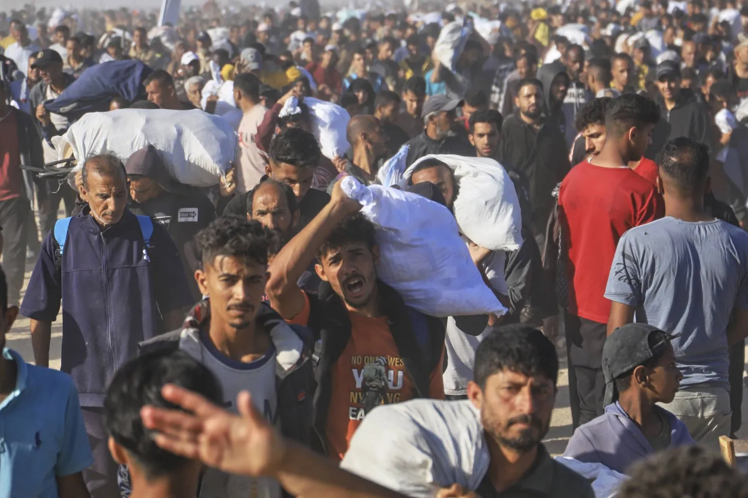 فلسطينيون يحملون صناديق وأكياساً تحتوي على مواد غذائية ومساعدات إنسانية مقدمة من مؤسسة غزة الإنسانية في رفح يوم 29 مايو 2025 (أ.ب)