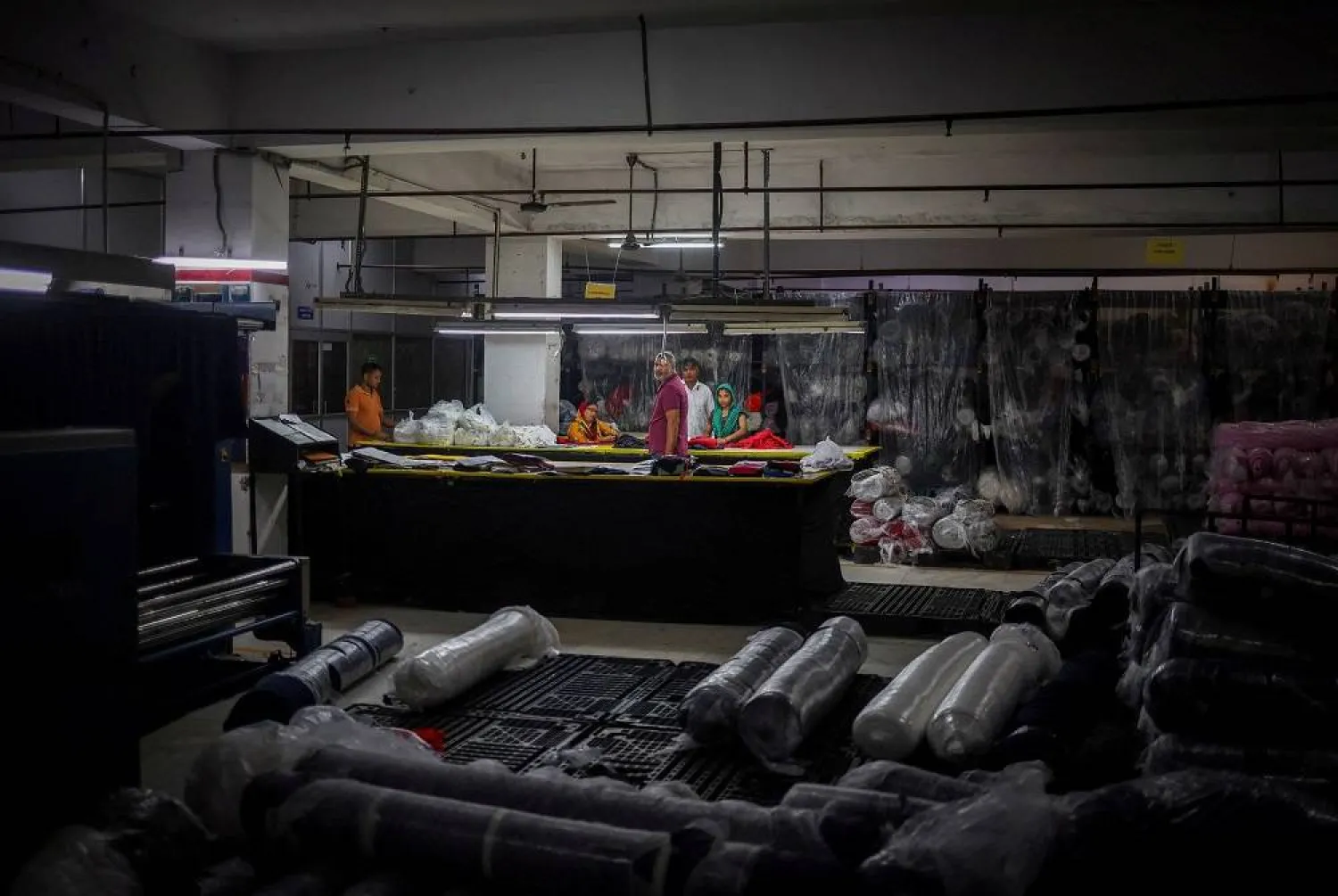 Workers look for fabrics for dresses inside a store at a garment manufacturing unit in Noida, India, August 27, 2025. (Reuters)