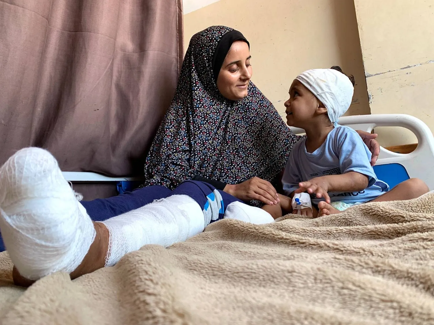 الطفل مصعب أبو محسن ووالدته في مجمع ناصر الطبي بخان يونس بعد إصابتهما في قصف إسرائيلي على خيمة العائلة (الشرق الأوسط)