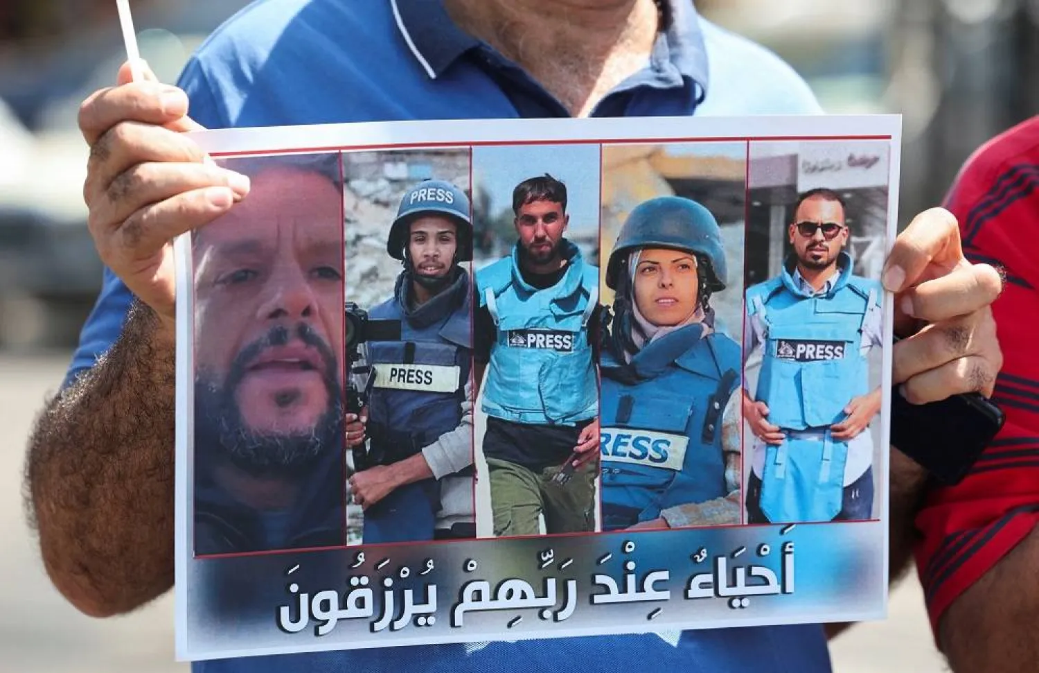 A demonstrator holds a poster featuring Reuters journalist Hussam al-Masri, Mohammed Salama, who worked for Qatar-based broadcaster Al Jazeera, Moaz Abu Taha, a freelance journalist who worked with several news organizations and occasionally contributed to Reuters, Mariam Abu Dagga, who freelanced for the Associated Press and other outlets, and Ahmed Abu Aziz, who were all killed in Israeli strikes on Nasser hospital in the southern Gaza Strip, during a protest in solidarity with journalists in Gaza, in Sidon, Lebanon, August 27, 2025. (Reuters) 