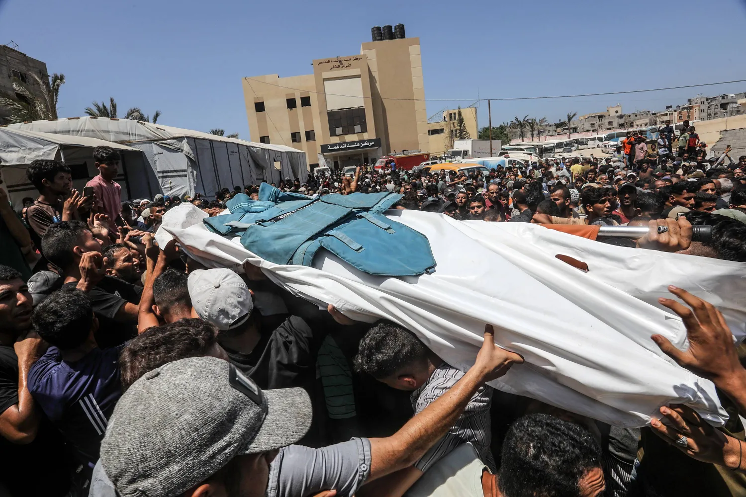 فلسطينيون يحملون جثمان صحافي قُتل في غارة إسرائيلية على مستشفى ناصر في خان يونس (د.ب.أ)