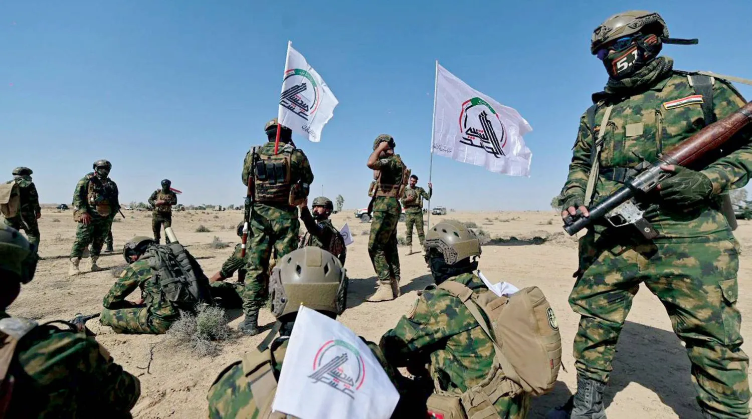  مقاتلون يرفعون شعار «الحشد الشعبي» خلال تدريبات عسكرية (موقع الهيئة)