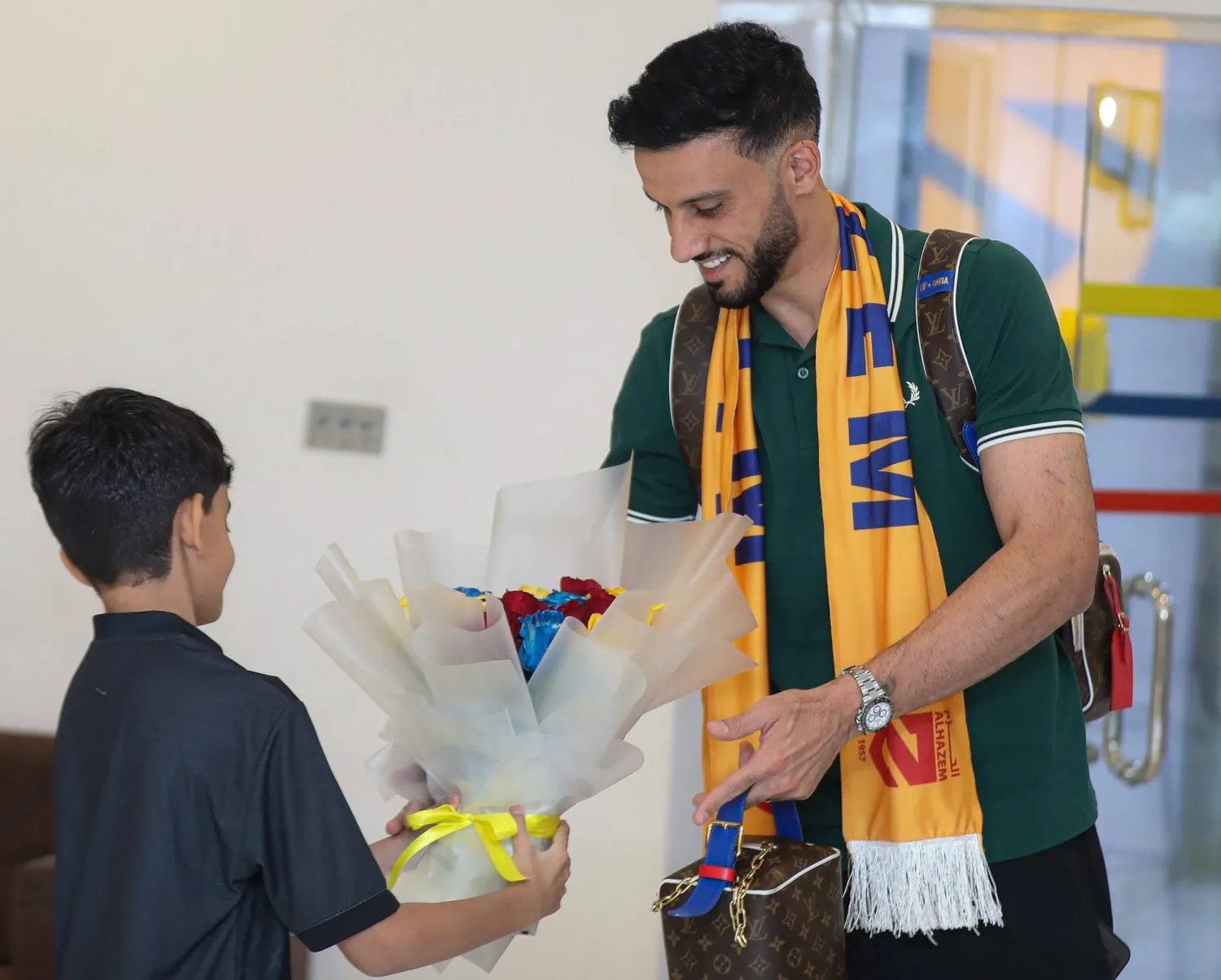 طفل يقدم باقة ورد للسومة عقب وصوله إلى الرس (نادي الحزم)