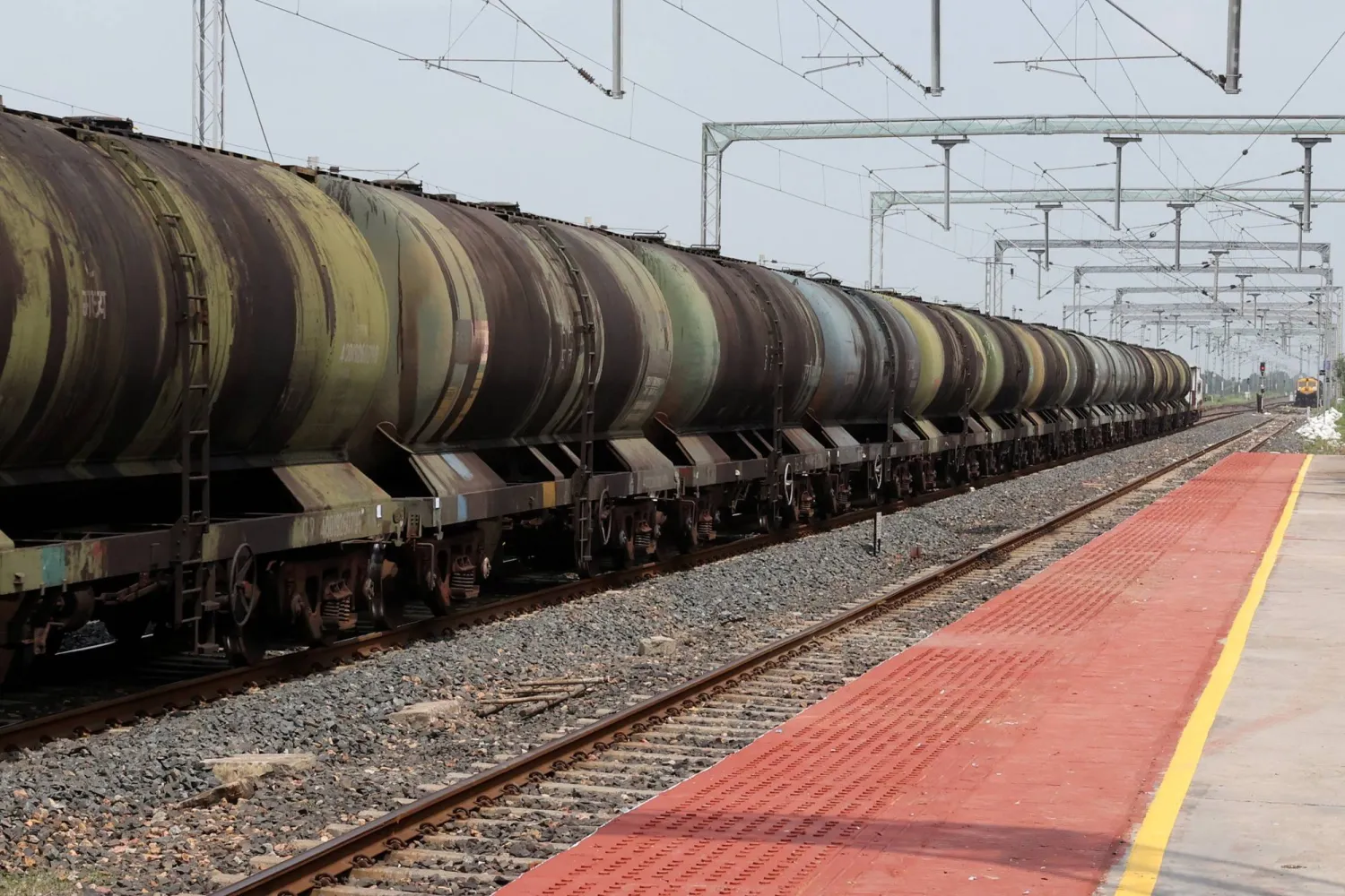 قطار ناقلة نفط يتحرك بالقرب من محطة سكة حديد على مشارف أحمد آباد بالهند (رويترز)