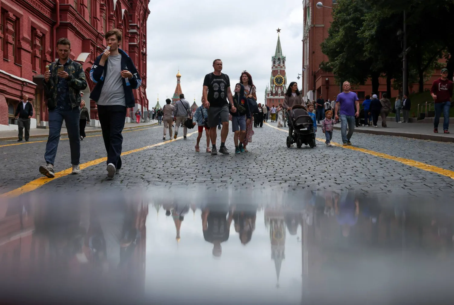 People walk outside Red Square, with St. Basil's Cathedral and the Kremlin's Spasskaya Tower seen in the background, in central Moscow, Russia, August 7, 2025. REUTERS/Evgenia Novozhenina