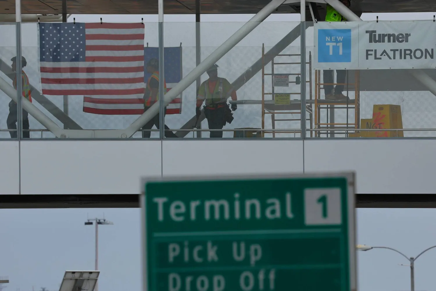 عمال بناء يقفون على ممر للمشاة في مبنى الركاب الجديد بمطار سان دييغو الدولي بكاليفورنيا (رويترز)