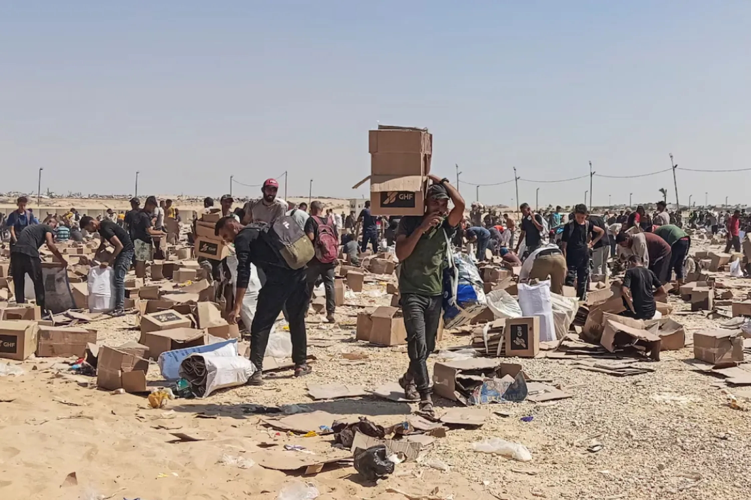 Palestinians gather to collect what remains of relief supplies from the distribution center of the US-backed Gaza Humanitarian Foundation, in Rafah, in the southern Gaza Strip, June 5, 2025. REUTERS