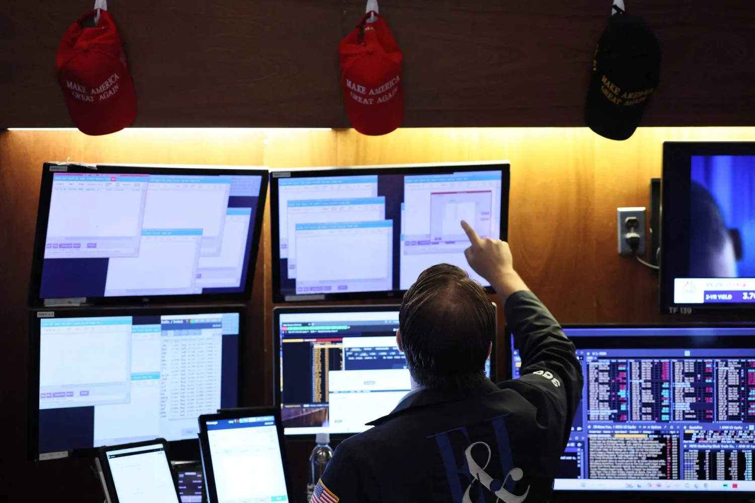 متداول يراقب شاشات تعرض مؤشرات الأسهم ببورصة نيويورك (أ.ف.ب)