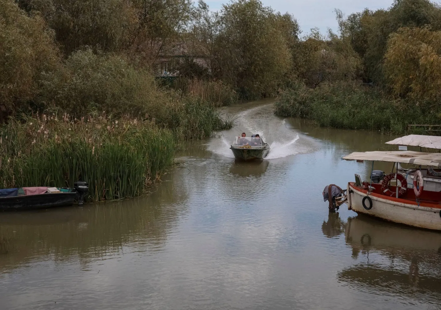 سكان يبحرون عبر قناة في قارب في بلدة فيلكوفي بمنطقة أوديسا الأوكرانية (رويترز - أرشيفية)