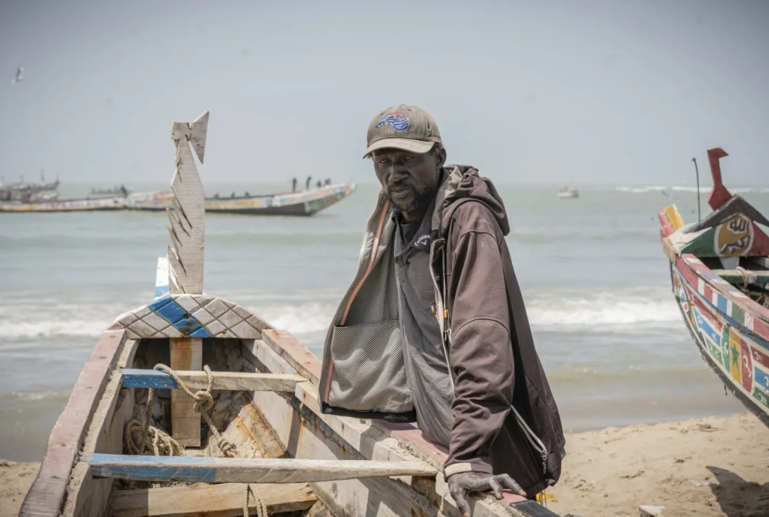 Famara Nudure, a fisherman for more than 40 years, leans against his boat in Gunjur, Gambia, after a day of work, on March 23, 2025. (AP Photo/Grace Ekpu)

