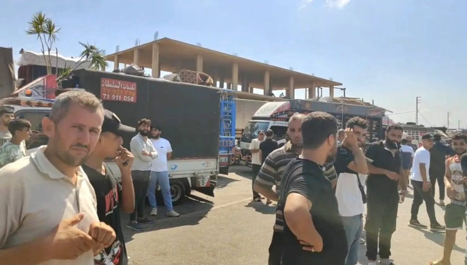 سوريون ينتظرون على معبر «العريضة» خلال رحلة العودة إلى سوريا (وكالة أخبار اليوم)