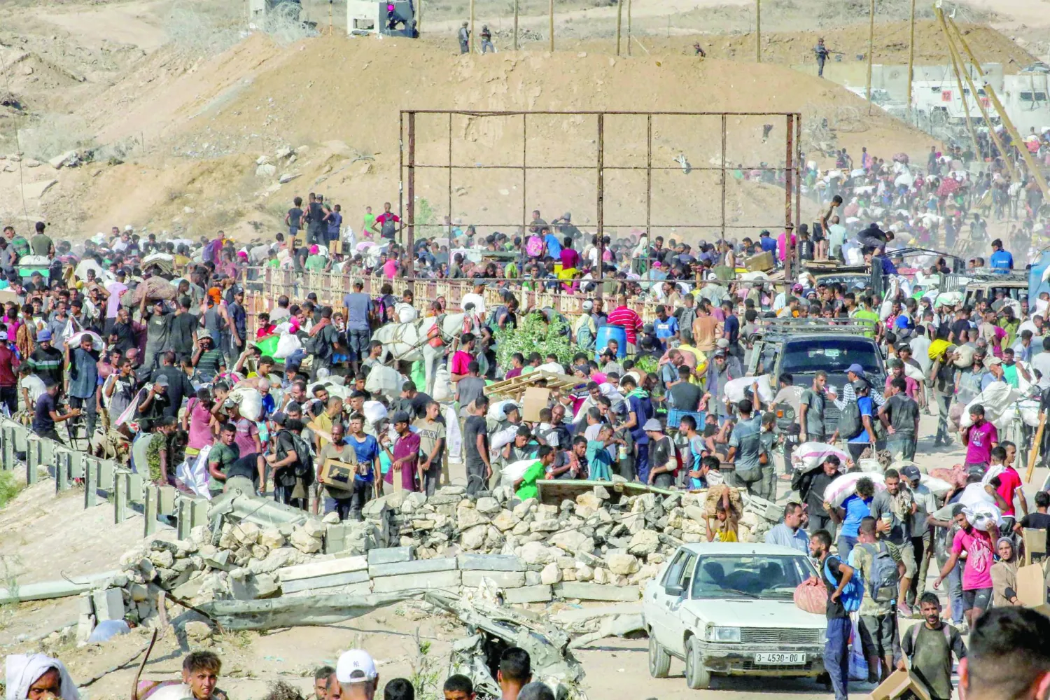 People walk with bags of humanitarian aid they received at a distribution center run by the US and Israeli-backed Gaza Humanitarian Foundation (GHF), as they cross the so-called "Netzarim corridor" in the central Gaza Strip, on August 22, 2025. (Photo by Eyad BABA / AFP)