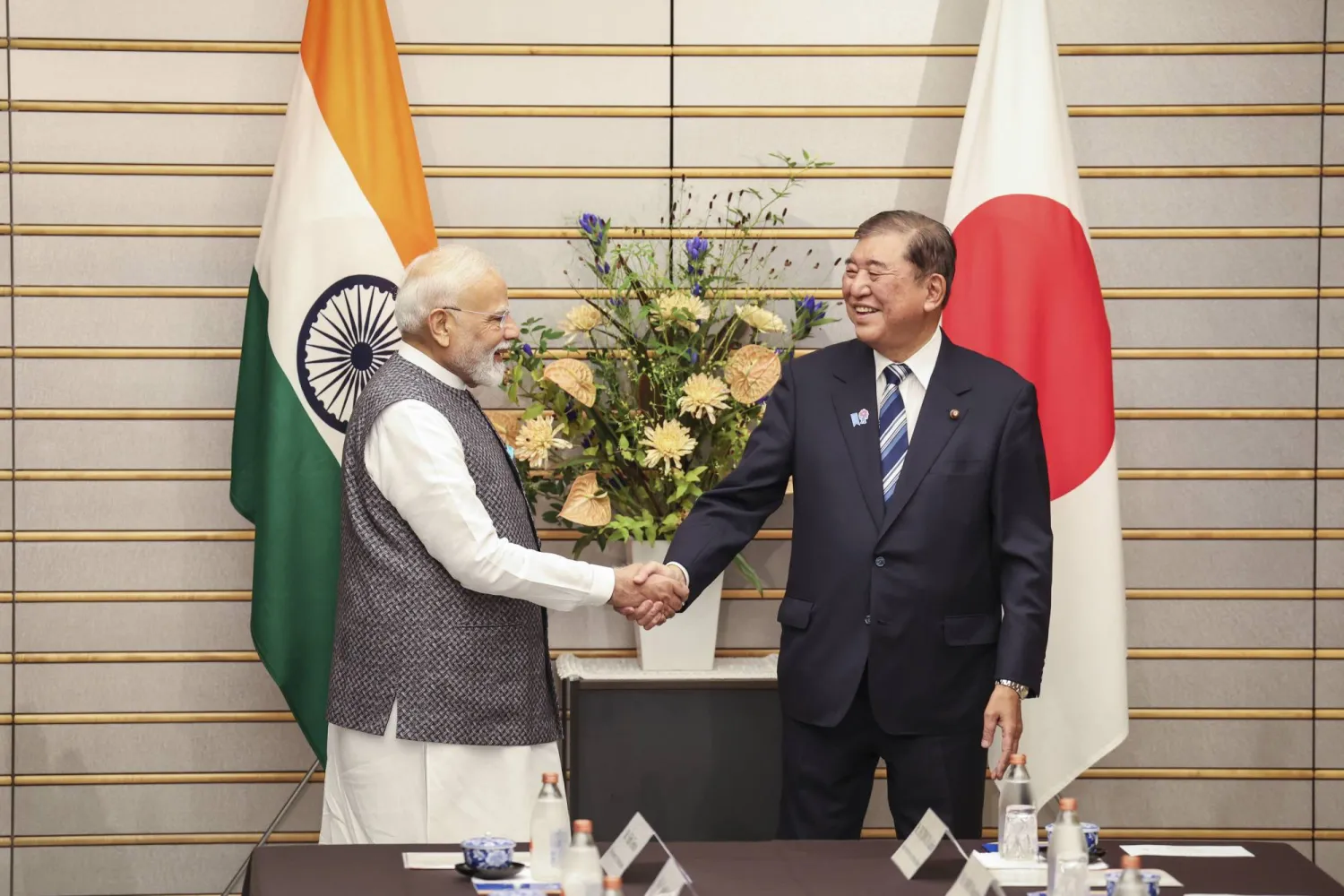 رئيس الوزراء الهندي ناريندرا مودي يصافح نظيره الياباني شيغيرو إيشيبا لدى وصوله إلى مقر الحكومة اليابانية في العاصمة طوكيو يوم الجمعة (أ.ب)