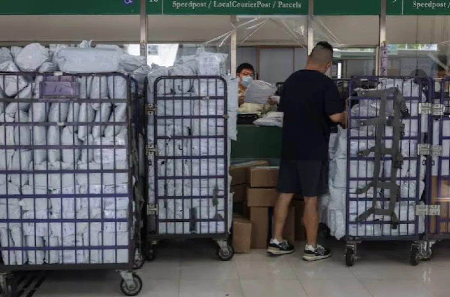 عامل بريد في هونغ كونغ يعالج طروداً متجهة للولايات المتحدة بعد قيود التعرفة الجديدة يوم 2 مايو 2025 (رويترز)