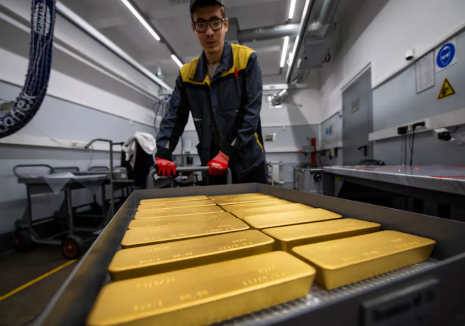 An employee transports ingots of 99.99 percent pure gold in a workroom during production at Krastsvetmet precious metals plant in the Siberian city of Krasnoyarsk, Russia, May 23, 2024. REUTERS/Alexander Manzyuk/ File Photo 