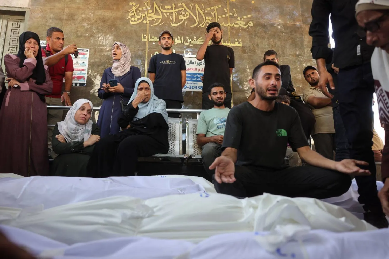 الحزن يُخيم على فلسطينيين خارج مستشفى الشفاء في مدينة غزة حيث نُقل ضحايا النيران الإسرائيلية قبل تشييع جنازاتهم (أ.ف.ب)