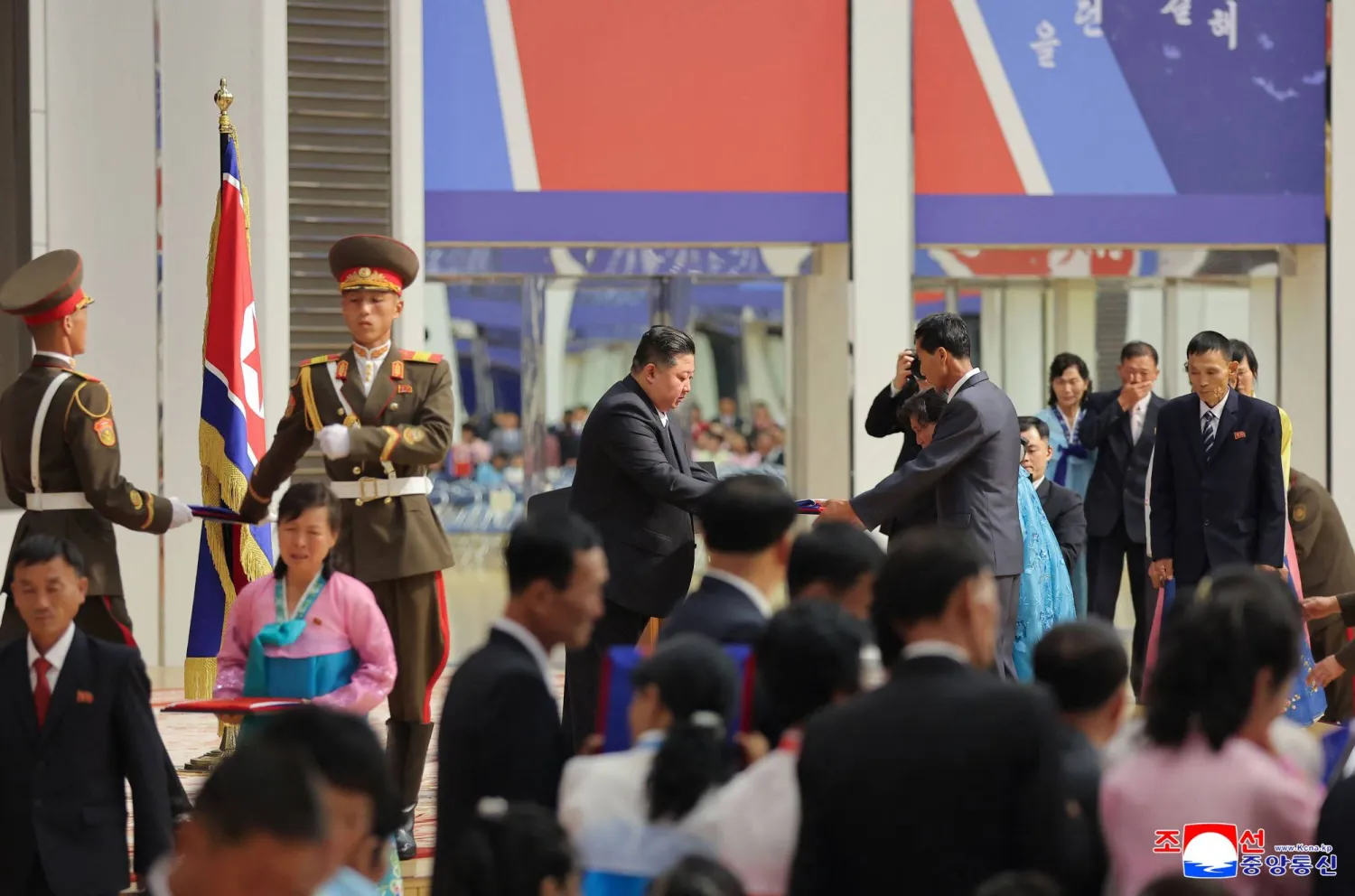 This picture taken on August 29, 2025 and released from North Korea's official Korean Central News Agency (KCNA) on August 30, 2025 shows North Korean leader Kim Jong Un handing over a portrait wrapped in the North Korean flag to the family of a soldier who participated in overseas military operations, in Pyongyang. (Photo by KCNA VIA KNS / AFP)/ 