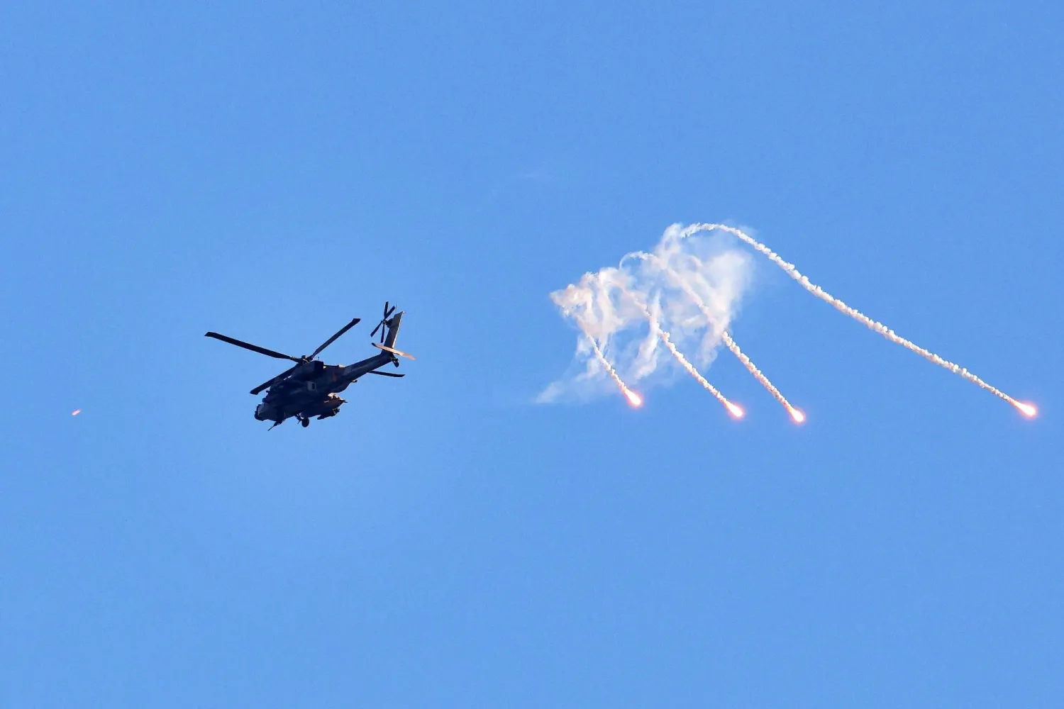 مروحية أباتشي إسرائيلية تطلق شعلات حرارية خلال تحليقها فوق قطاع غزة (أ.ف.ب)