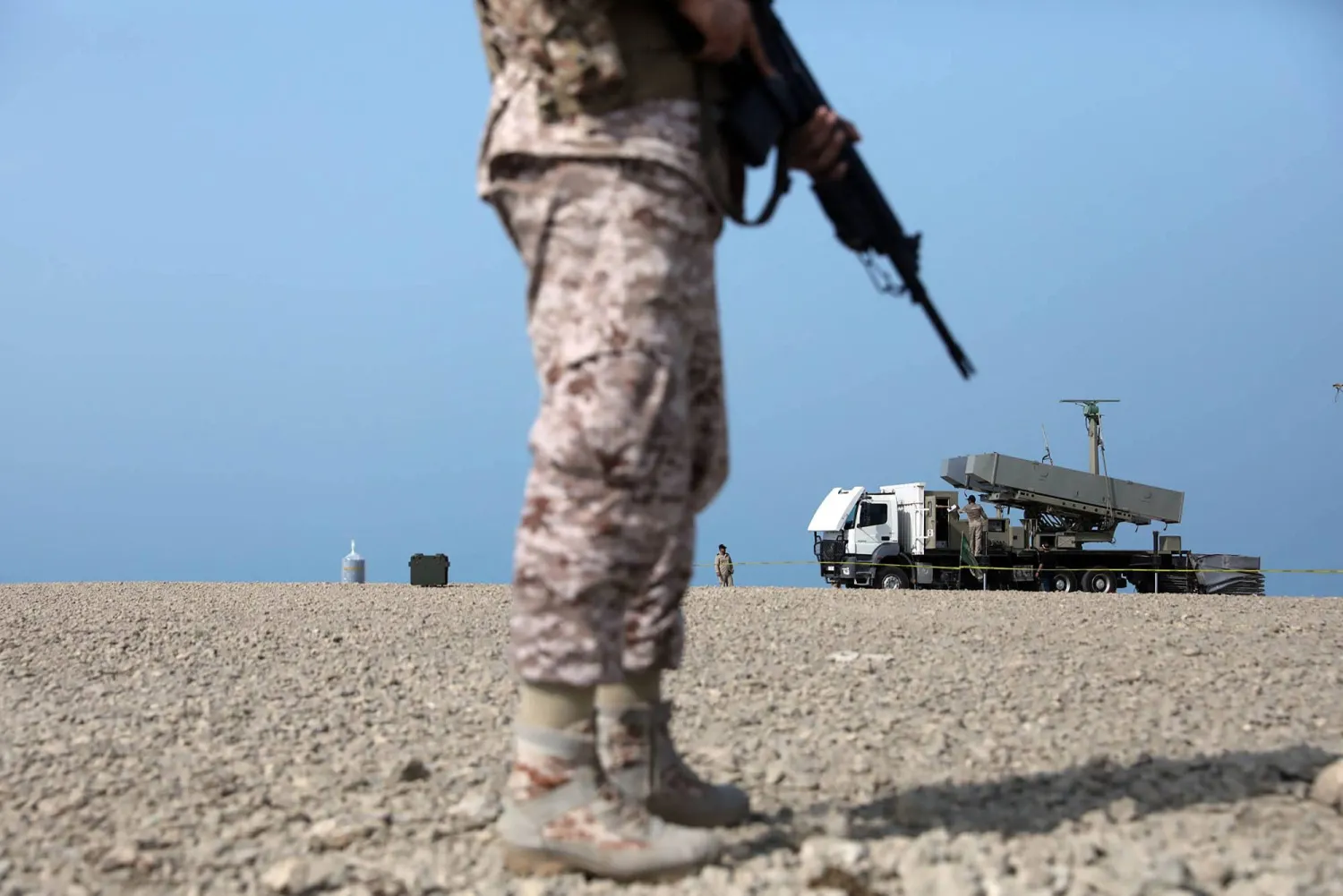 جندي يقف بالقرب من قاذفة صواريخ خلال تدريب عسكري بجنوب إيران (أ.ف.ب)