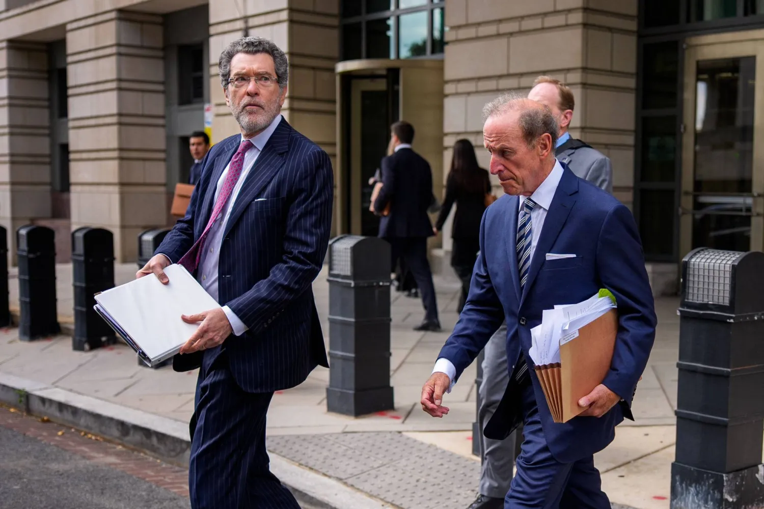 المحاميان نورمان آيزن (يسار) وآبي لوفيل (يمين) اللذان يمثلان ليزا كوك يغادران المحكمة الفيدرالية (أ.ف.ب)