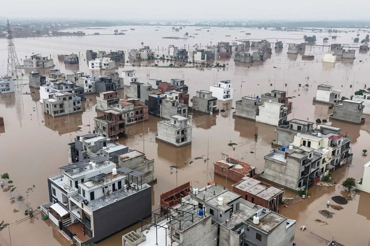 This aerial view shows partially submerged residential buildings following the overflowing of the Ravi River in Lahore on August 30, 2025. (Photo by Aamir QURESHI / AFP)