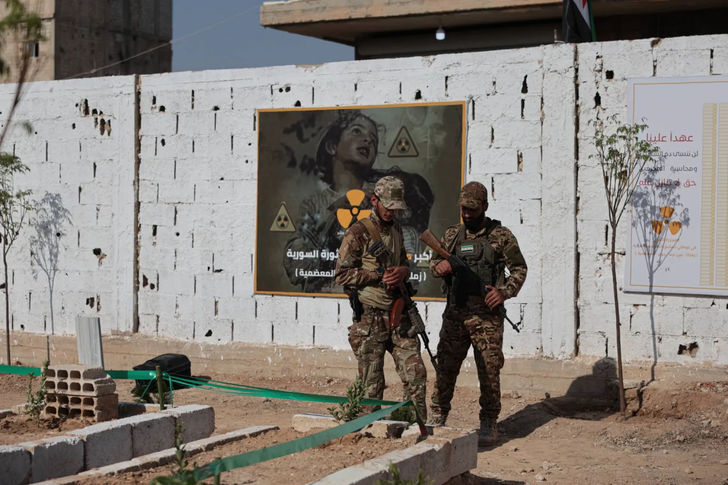 عنصران من الجيش السوري يظهران في منطقة على مشارف دمشق (إ.ب.أ)