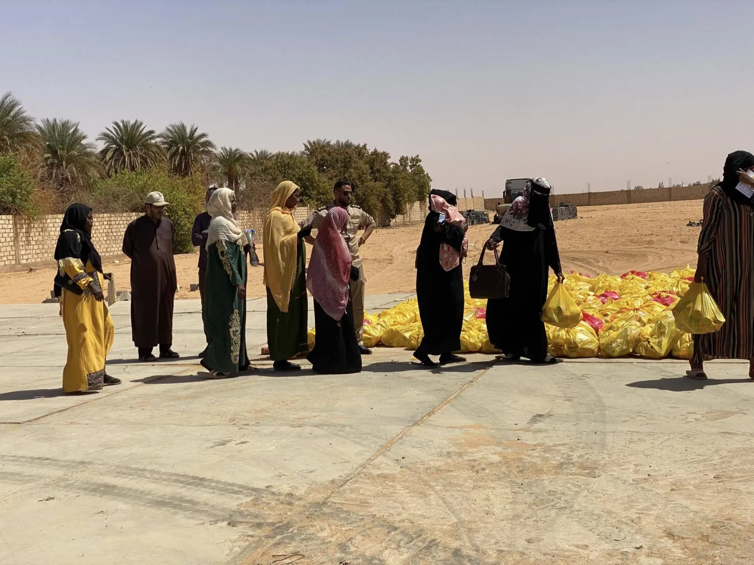 من عمليات توزيع مساعدات على النازحين السودانيين في الكفرة الليبية (المكتب الإعلامي للبلدية)