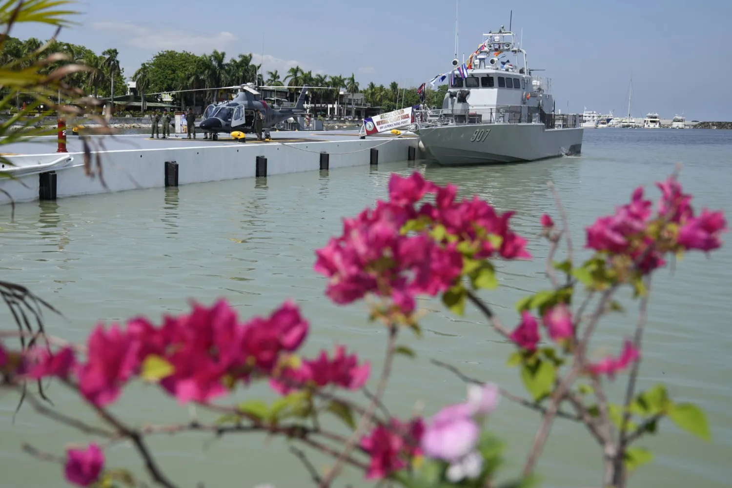 FILE - Navy men stand beside an AW109E helicopter and BRP Laurence Narag ship as they are displayed during the 126th Philippine Navy anniversary in Manila, Philippines on Friday, May 24, 2024. (AP Photo/Aaron Favila, file)