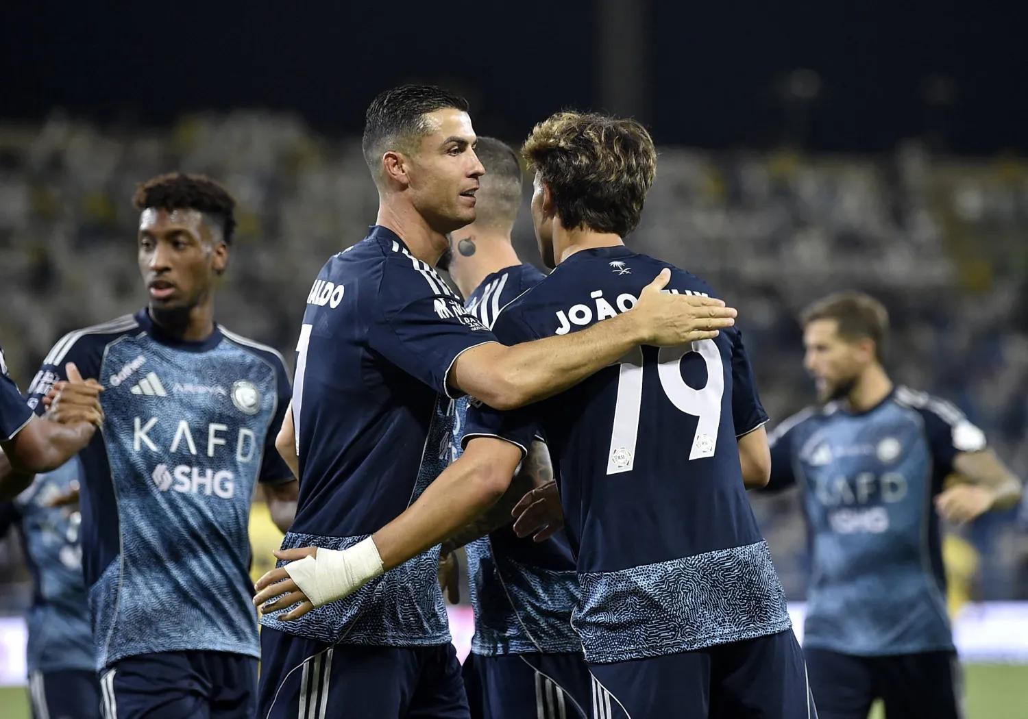 فيليكس يتلقى تهنئة رونالدو عقب أحد أهدافه أمام التعاون (رويترز)