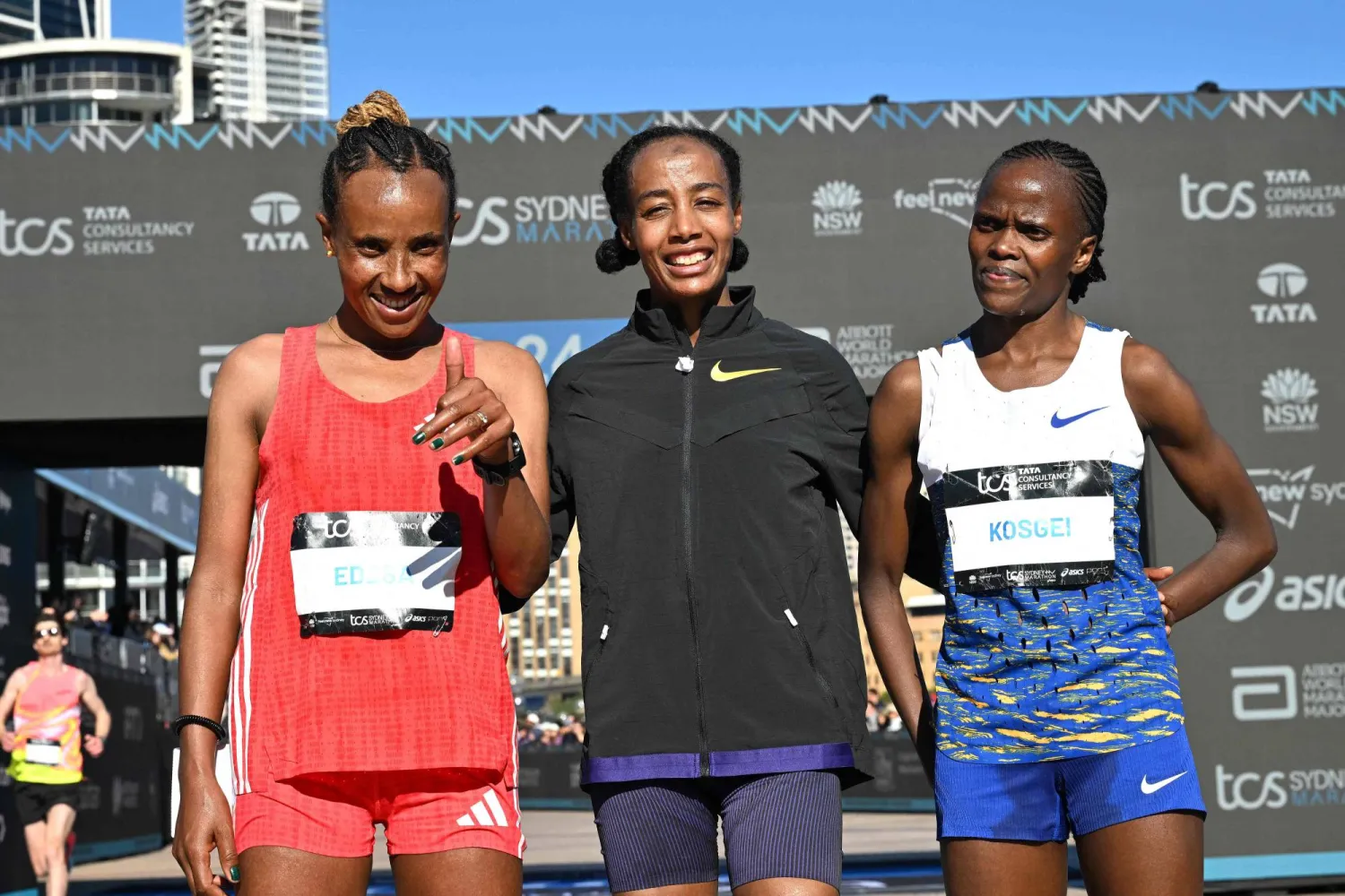 سيفان حسن خلال التتويج وبجانبها الكينية بريجيد كوسغي والإثيوبية ووركنش إديسا (أ.ف.ب)